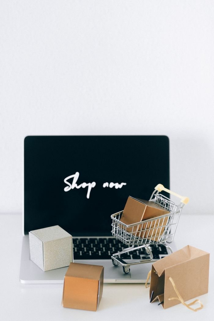 Services Minimalist online shopping setup with laptop, cart, and packages symbolizing e-commerce.
